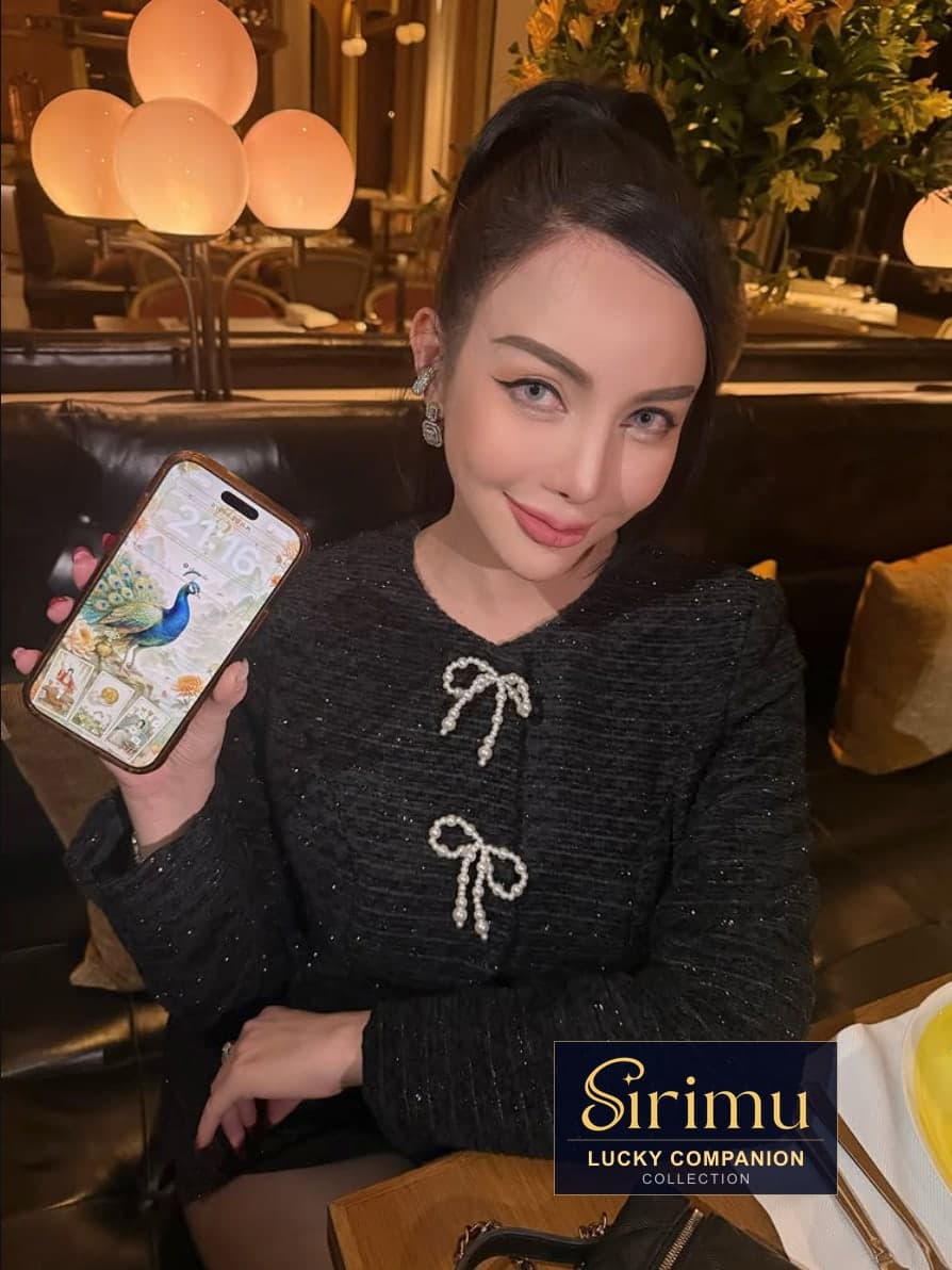 คุณ airly_valentine ถือโทรศัพท์ที่แสดงวอลเปเปอร์นกยูงเฉพาะบุคคลจาก SIRIMU